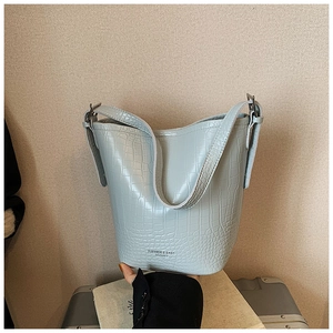 Detail of light blue-grey bucket bag showing crocodile embossed leather and silver buckles