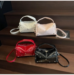 Detail of multi-color heart-studded bags with ruffled sides and shiny finish