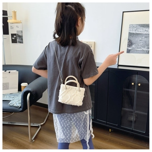 Détail du petit sac rond blanc pour enfant en tweed texturé avec bandoulière chaîne argentée