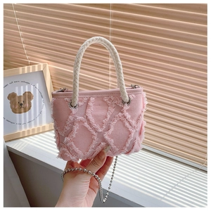 Détail du mini sac en denim rose avec bords frangés, poignée en corde et chaîne argentée