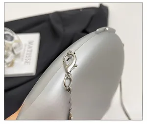 Detailed macro view of high-quality silver metal chain and lobster clasp for shell bag