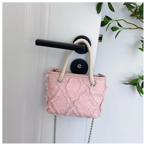 Détail du sac bandoulière en denim rose avec motif losange effiloché et poignée