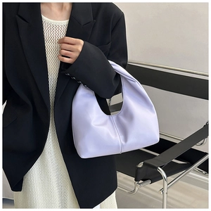 Detail of lavender crescent handbag featuring a center seam stitch and minimalist design