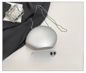 Silver oval shell clutch bag size comparison with smartphone and elegant snake chain