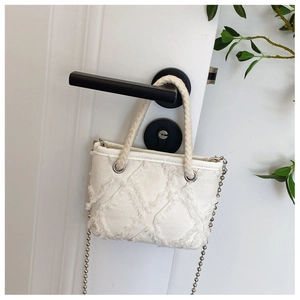 Détail du mini sac en toile crème avec franges et bandoulière chaîne à billes