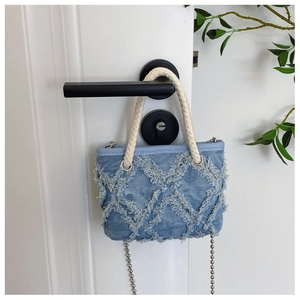 Détail du mini sac en jean bleu avec texture à franges et poignée en corde tressée