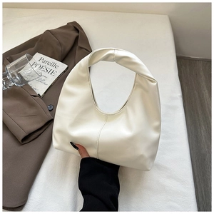 Chic off-white hobo bag with unique knotted handle displayed in a retro lifestyle setting