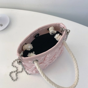 Détail d'un sac en toile rose à franges montrant la doublure et le fermoir magnétique en métal