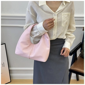 Close-up of the pastel pink hobo bag featuring matte leather texture and vertical stitching