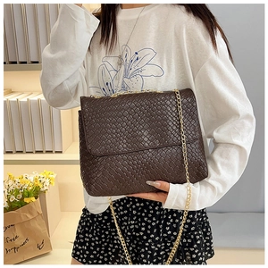 Close-up of a dark brown woven leather bag with a refined gold chain shoulder strap
