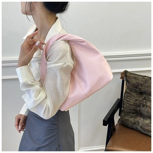 Close-up of a light pink cloud hobo bag with matte leather and stitched seam detailing