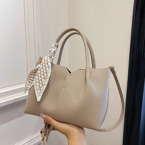 Minimalist beige pebble leather tote bag with decorative scarf and detachable strap