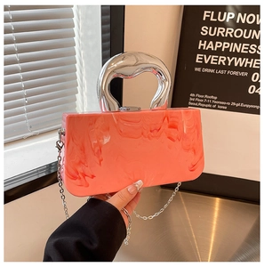 Détail de la pochette de soirée en acrylique corail marbré avec poignée en métal argenté