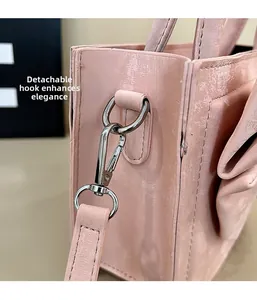 Detail of pink leather handbag showing the detachable metal hook and D-ring attachment