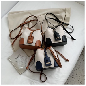 Three-color bucket bags in canvas and leather arranged with lifestyle props for summer