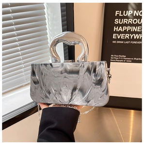 Détail d'un sac à main effet marbre avec poignée en U argentée et bandoulière chaîne