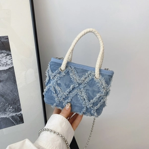 Petit sac rond en denim bleu clair avec motif losange effiloché et bandoulière argentée