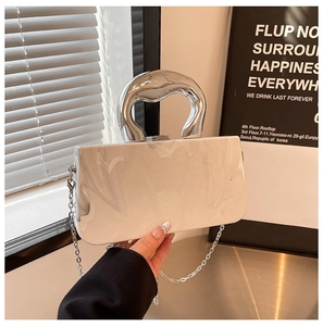 Gros plan d'une pochette en acrylique blanc marbré avec poignée ronde en métal argenté