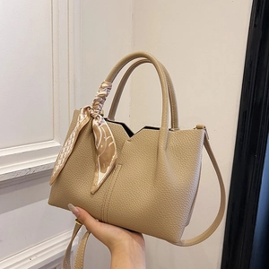 Minimalist beige pebble leather tote bag with decorative silk scarf and shoulder strap