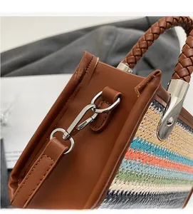Detailed close-up of colorful woven bag with durable silver metal hook and leather trim