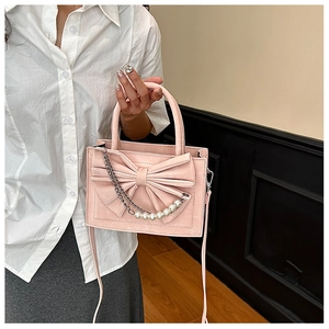 Detail of pink bow handbag with pearl metal chain and elegant shoulder strap