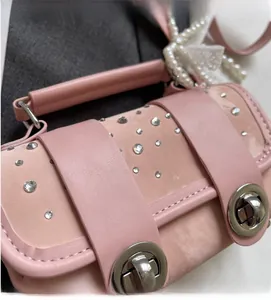 Detail of pink rhinestone bag with pearl handle and metallic twist lock closure