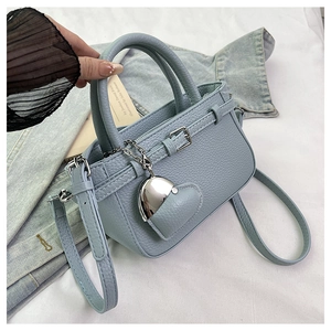 Detail of light blue lychee pattern bag with heart pendant and buckle decoration
