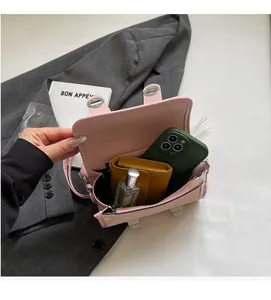 Detailed interior view of a pink leather crossbody bag with items showing storage capacity