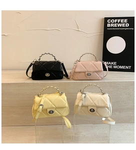 Dettaglio di borse trapuntate in nero, rosa, giallo e beige con manici a catena in metallo