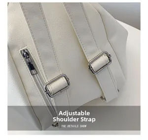 Detail of adjustable straps and silver metal buckles on a white lychee grain PU backpack