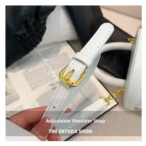 Detail of adjustable shoulder strap with gold metal buckle on minimalist white leather bag