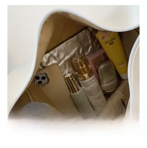 Internal view of a spacious white leather bag showing large capacity for personal items