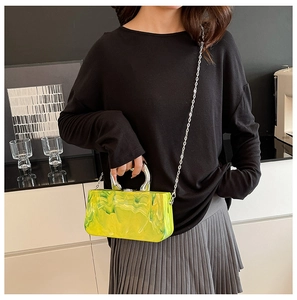 Détail du sac à main en acrylique marbré néon avec poignée en métal sur modèle