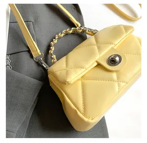 Dettaglio della borsa trapuntata giallo brillante con catena e chiusura girevole