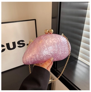 Detail of pink marble acrylic clutch bag with gold spherical clasp and chain strap