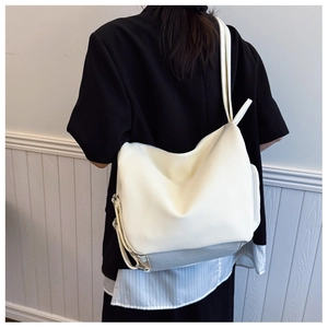Detail of creamy white litchi textured leather hobo bag with adjustable side strap