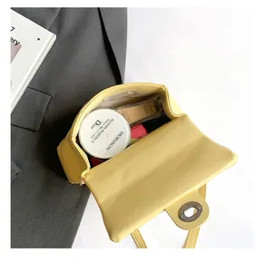 Dettaglio dell'interno di una borsa gialla trapuntata con cosmetici e trucco