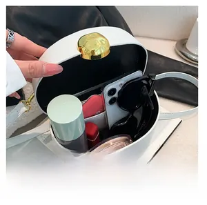 Detail view of white oval shoulder bag open showing interior storage for daily essentials