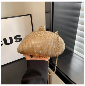 Detailed view of acrylic clutch bag with marble texture and golden spherical clasp