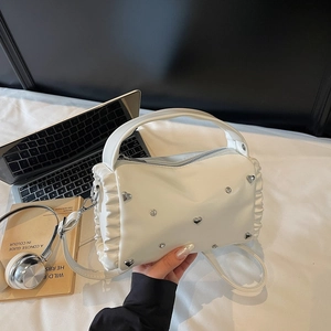 White cylinder shoulder bag with ruffled edges and metallic heart rivets for women