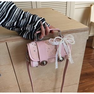Detailed shot of pink leather bag with sparkling rhinestones and white lace bow