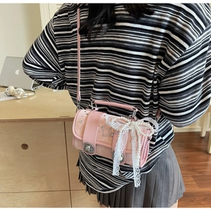 Detailed view of pink pillow bag with rhinestones, lace bows and pearl chain strap