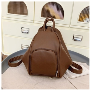 Detail view of a dark brown lychee leather backpack with a unique teardrop design