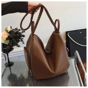 Detailed view of brown lychee grain faux leather tote bag with vertical zipper side pockets