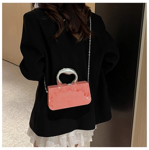 Sac de soirée en acrylique marbré rose avec poignée argentée et détail de chaîne
