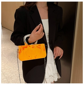 Détail de la pochette de soirée en acrylique orange avec poignée argentée et chaîne