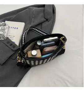 Spacious interior of houndstooth crossbody bag showing phone and wallet storage