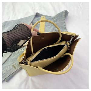 Detail view showing the yellow lychee grain leather tote bag with internal zip pouch