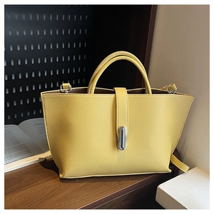 Close-up of yellow litchi pattern leather tote bag with silver metal twist lock buckle