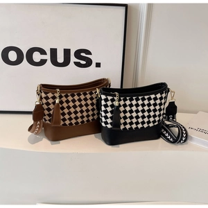 Detail view of plaid bucket bags with wide straps in brown and black vintage patterns